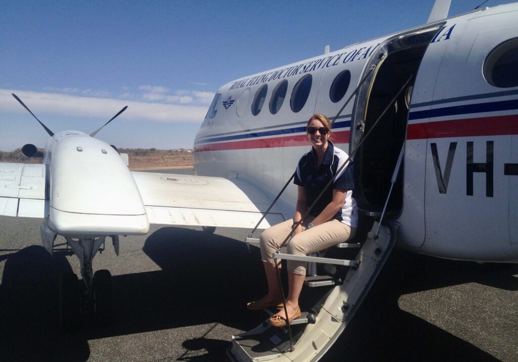 Steph sat on the steps of an RFDS aircraft.